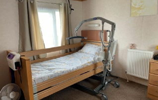 Profile bed, pressure mattress and hoist in a large accessible bedroom at caravan Susan in Kent.