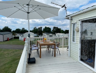 Outdoor dining on the veranda at accessible caravan Susan based at Allhallows, Kent 